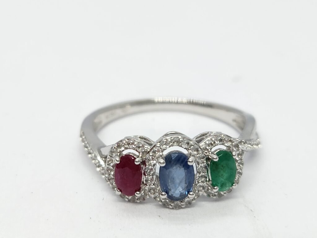 Elegante anillo de diseño con tres gemas centrales y 56 topacios - Montura de platino. - Tres gemas centrales: rubí, zafiro y esmeralda. - Acompañado topacios gemas incrustadas en el aro. platino 950 talla 22 peso 4,99gr