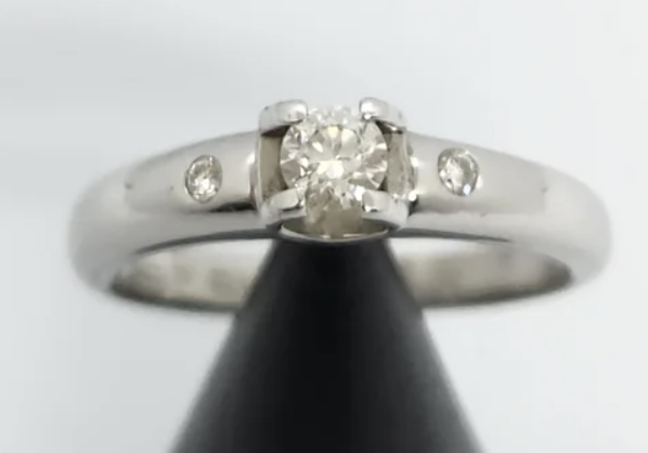 Precioso anillo de oro blanco 18k Con un diamantes central de aprox. 0,30 en talla brillante. Y dos diamantes laterales. Talla 25 Peso 6,22gr.