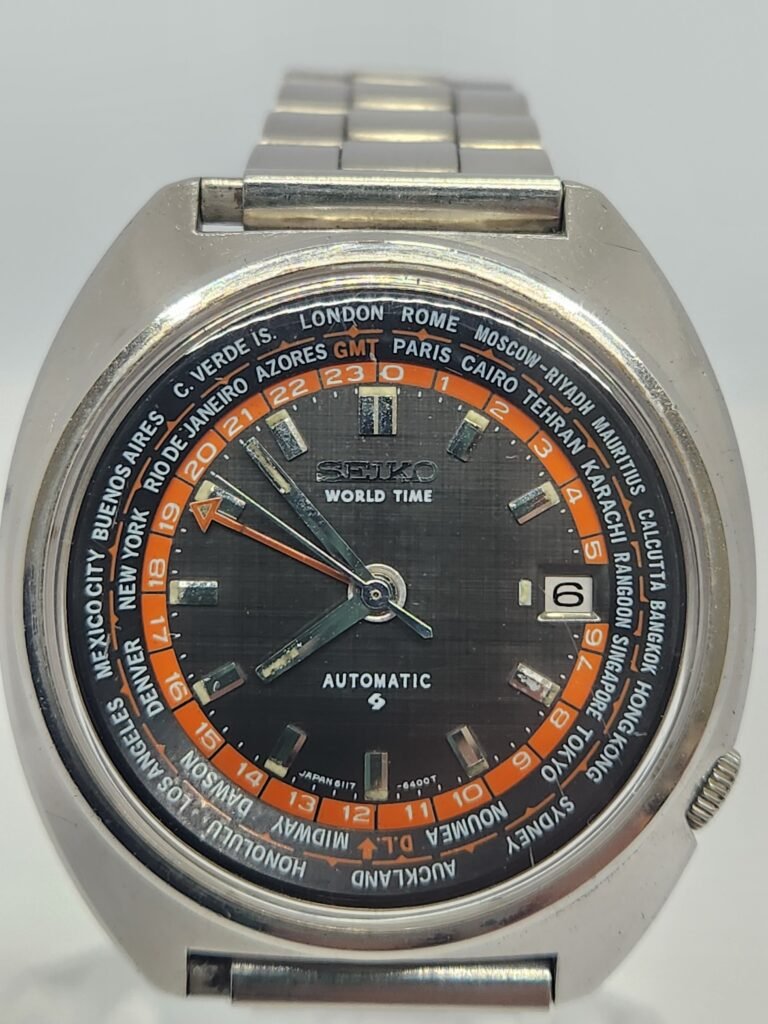 Seiko World Time automático, modelo 6117-6400. Un clásico para los amantes de los relojes. - Bisel giratorio con ciudades del mundo. - Indicador de fecha. - Movimiento automático. - Caja y brazalete de acero inoxidable.